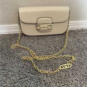 Cream bag with gold chain and shoulder strap